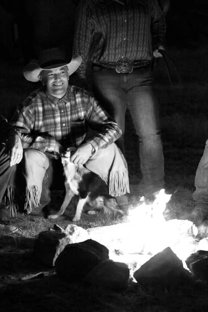 istock monochrome smiling lone cowboy outdoors at dusk by campfire 841037596