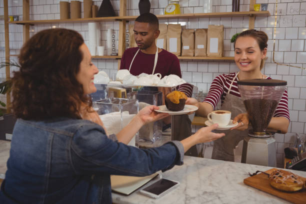 istock Owner serving muffin and coffee to customer 841037824