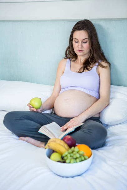 istock Pregnant woman reading a book 841040112