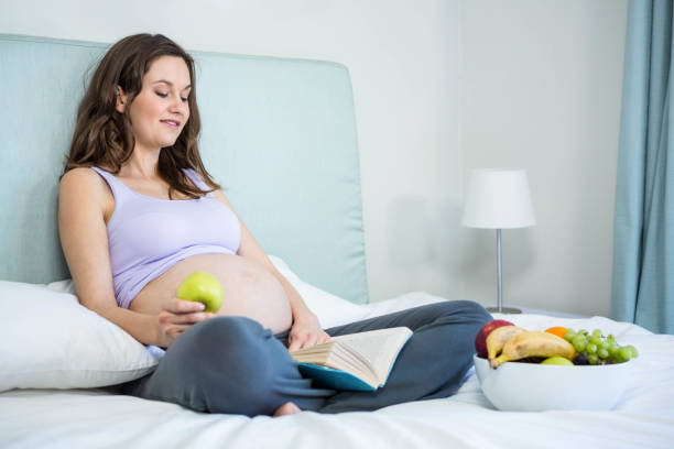 istock Pregnant woman reading a book 841040120