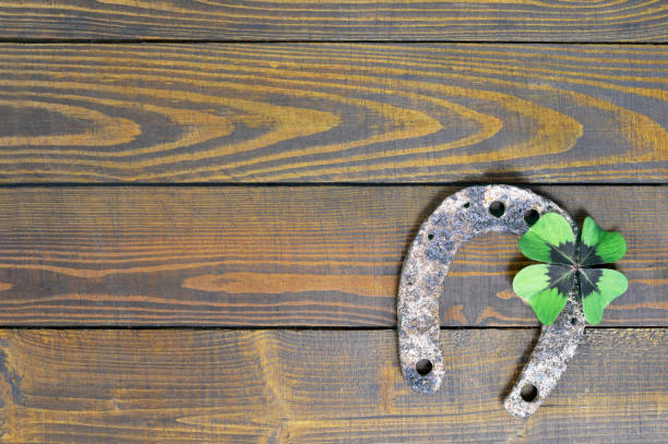 istock Horseshoe and lucky clover on wooden background 841040234
