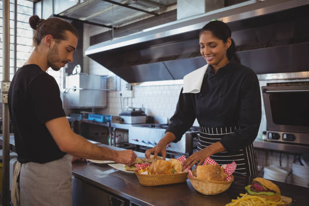 istock Waitress with coworker arranging plate with food at cafe 841040236