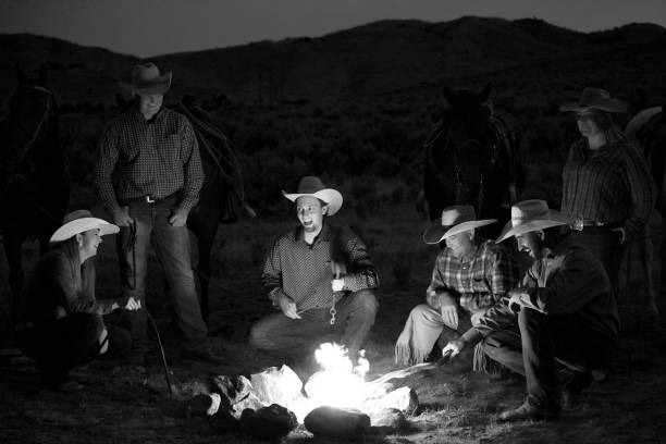 istock monochrome smiling cowboys outdoors at dusk by campfire 841040524