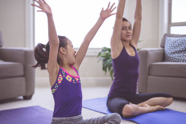 istock Woman doing yoga pose inside with daughter 841045342