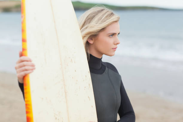 istock Beautiful young woman with surfboard on beach 841045350