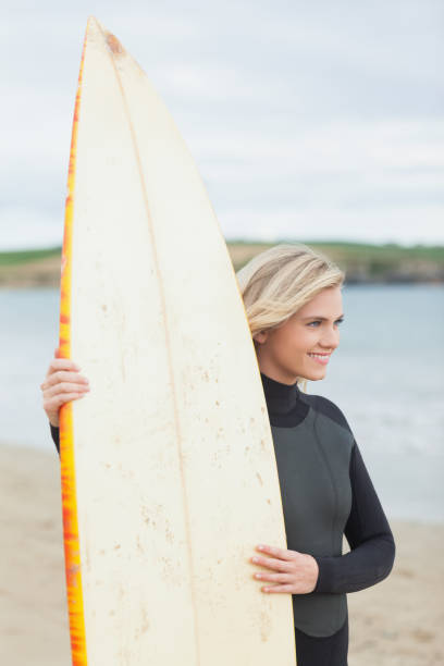 istock Smiling beautiful woman with surfboard on beach 841045358