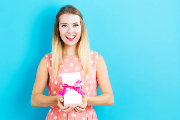 istock Happy young woman holding a gift box 841050734