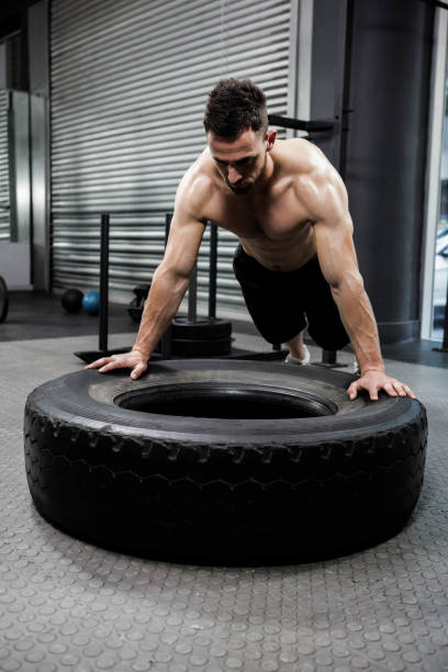 istock Shirtless man flipping heavy tire 841051126