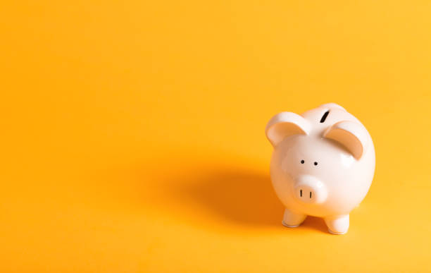 White piggy bank on yellow White piggy bank on a yellow background piggy bank photos stock pictures, royalty-free photos & images
