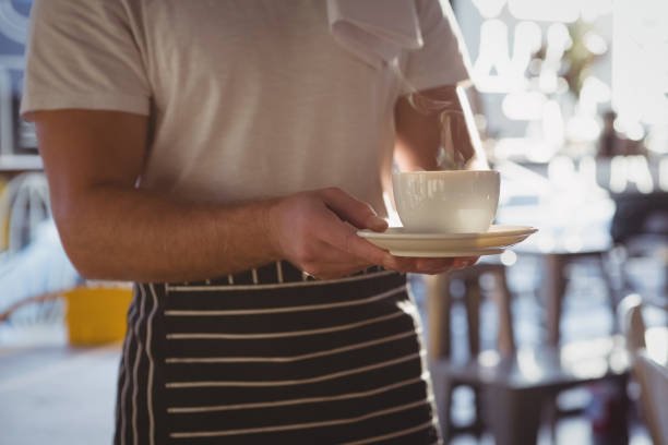 istock Mid section of waiter holding coffee cup 841056712