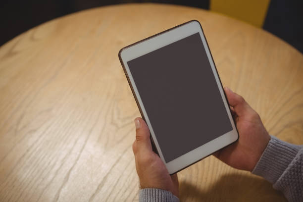 istock Cropped hand of man holding tablet at table 841057056