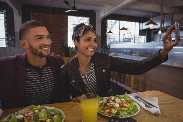 istock Friends with salad plates taking selfie in cafe 841069050