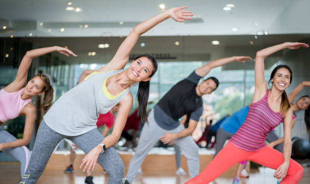Happy people in an aerobics class at the gym Group of people in an aerobics class at the gym stretching looking very happy â fitness concepts exercise class photos stock pictures, royalty-free photos & images