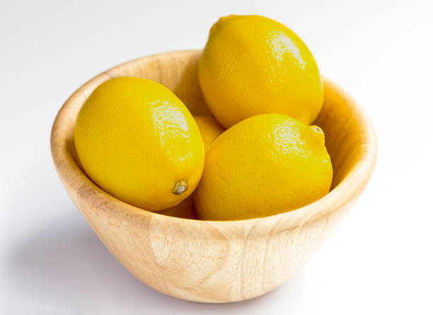 istock lemon with wooden bowl on white background. 841071984