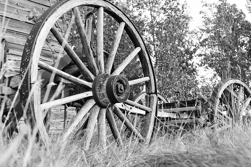 A black and white image of old fashioned wagon wheels.