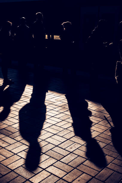 istock People waiting on railway station: summer silhouettes and shadows 841083398