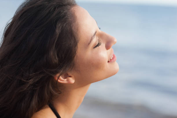 istock Cute young woman with eyes closed at beach 841083738