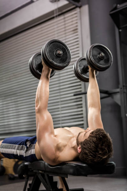 istock Shirtless man lifting heavy dumbbells on bench 841086958
