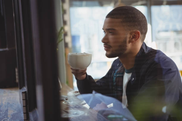 istock Thoughtful young man having coffee in cafe 841090484