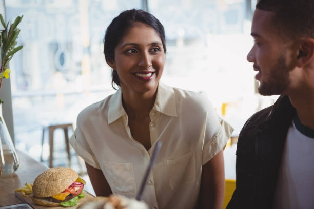 istock Happy young woman looking at man in cafe 841090692