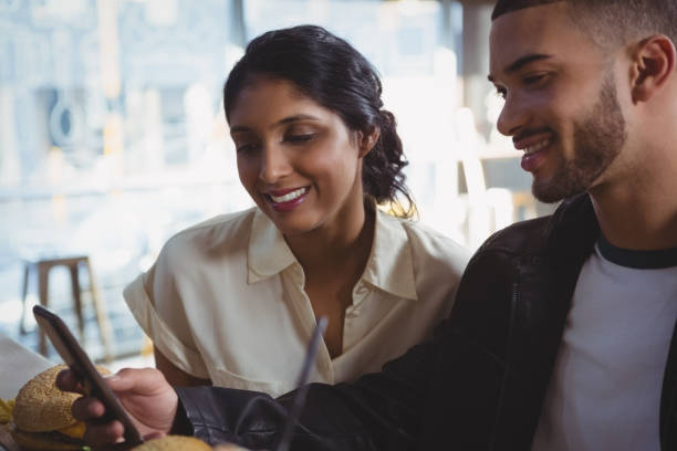 istock Man with woman using phone in cafe 841090700