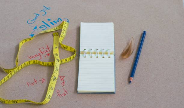 istock Notepad with measuring tape, pencil on wood board background.using wallpaper diet or lose weight image.Take note the product for book with paper and concept or objective and copy space. 841094522