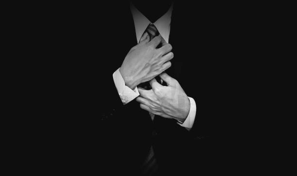 homme d’affaires en costume noir sur fond noir, noir et blanc - smoking issues photos photos et images de collection
