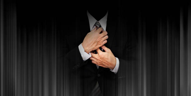 istock Businessman in black suit on panoramic black background 841103472