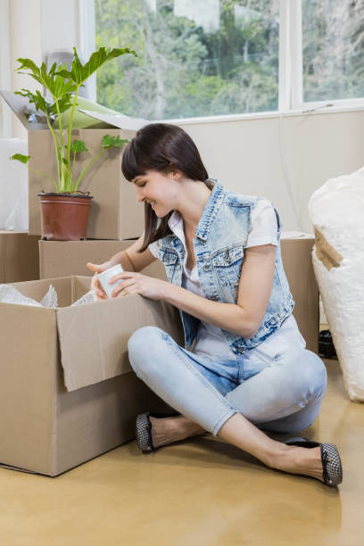 istock Young woman unpacking carton boxes 841106678