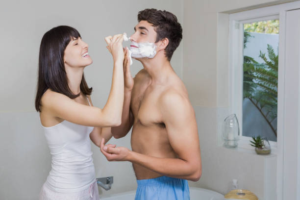 istock Young woman applying shaving cream on young mans face 841107040