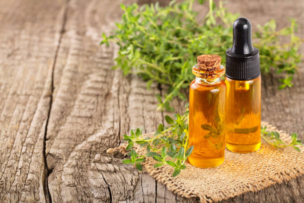 istock Bottle of essential oil with herbs thyme isolated on white background 841114252