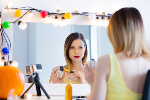 istock blogger woman applying cosmetics at camera 841114704