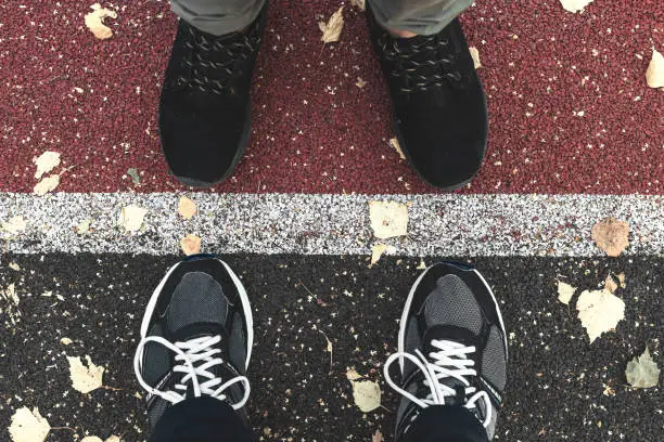 Sneakers on the sports ground in the fall. two people