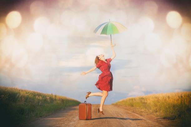 istock woman with suitcase and umbrella 841122216