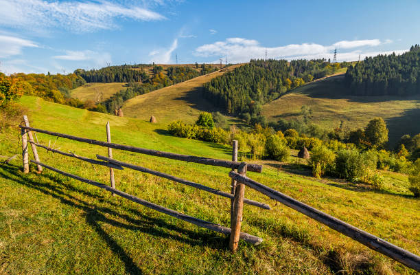 istock hay stacks behind the fence on rural field 841129668