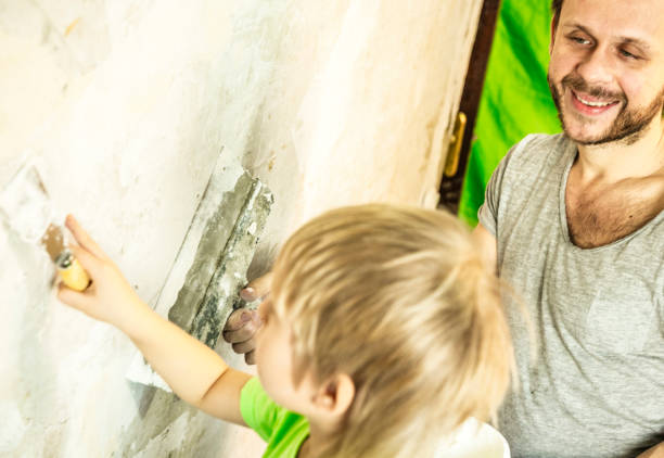 father and son with trowel plastering a wall - plaster plasterer work tool child imagens e fotografias de stock