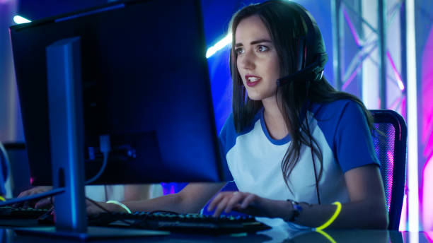 piękna profesjonalna dziewczyna gracza i jej zespół biorą udział w turnieju esport cyber games. ona ma słuchawki i kolorowe band na. - pc game zdjęcia i obrazy z banku zdjęć