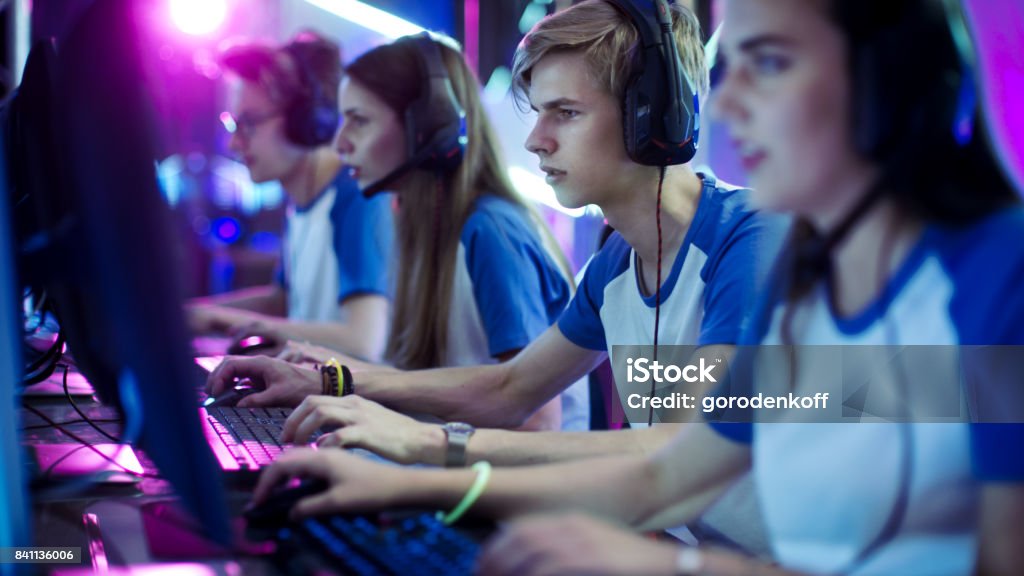 Team of Professional eSport Gamers Playing in Competitive Video Games on a Cyber Games Tournament. They using Microphones. eSports Stock Photo