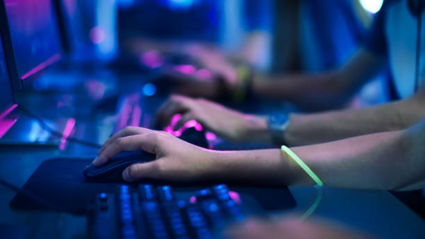 zbliżenie na wiersz gamer's hands na keyboard.jpgs, aktywnie naciskając przyciski, grając w gry mmo online. tło jest oświetlone neonami. - hand games zdjęcia i obrazy z banku zdjęć