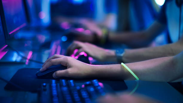 close-up na linha de gamer mãos em um keyboard.jpgs, ativamente, apertando botões, jogando jogos de mmo online. plano de fundo é iluminado com luzes de néon. - hand games - fotografias e filmes do acervo