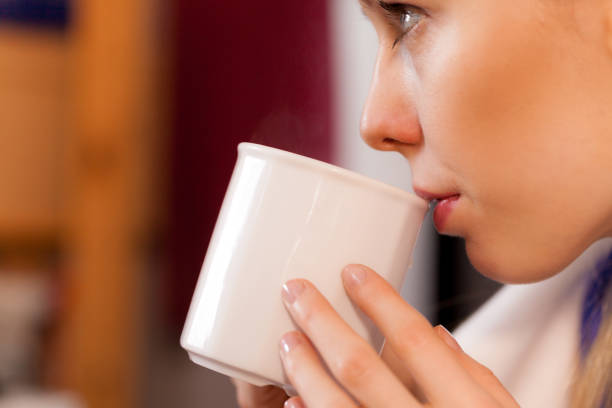 istock Closeup of woman drinking from white mug 841140576
