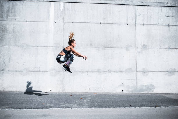 alto en el aire - jumping women running vitality fotografías e imágenes de stock