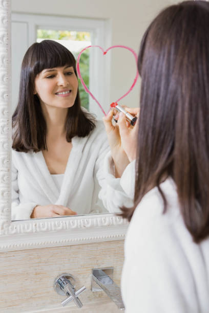 istock Young beautiful woman drawing big heart on mirror 841144132