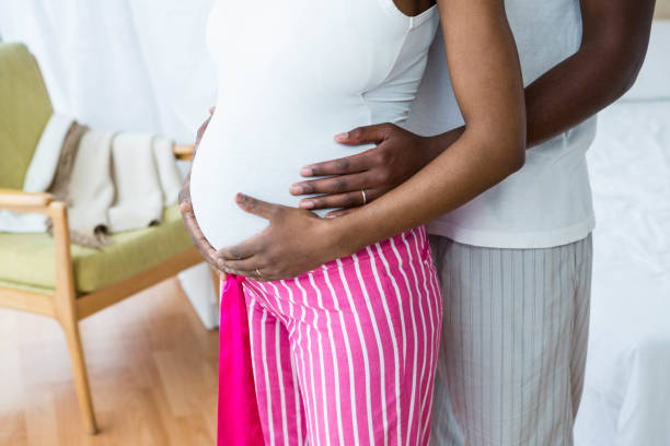 istock Pregnant couple embracing in bedroom 841146748