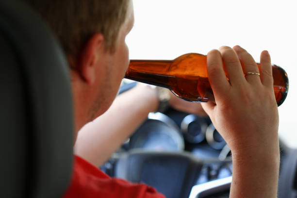 istock A man drinks alcohol while in the car holding a bottle in his hand 841148232