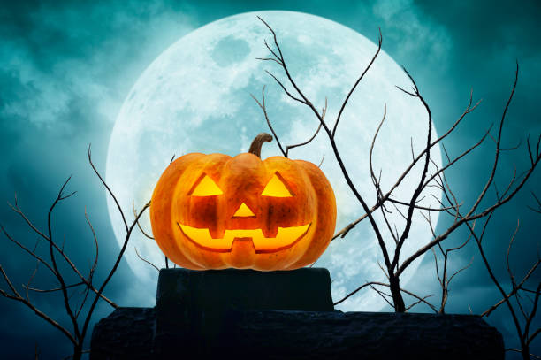 istock Jack O Lantern pumpkin on the rock over dead tree and moon 841154998