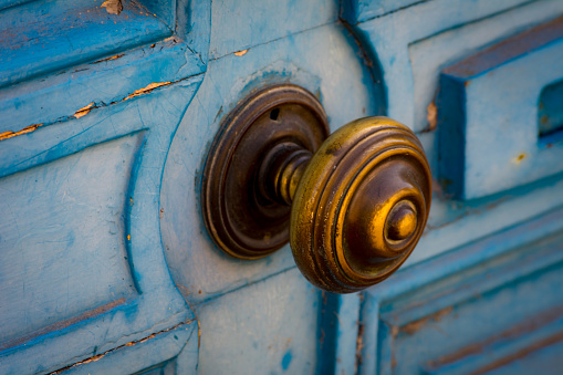 Vintage blue door with patina and brass knob