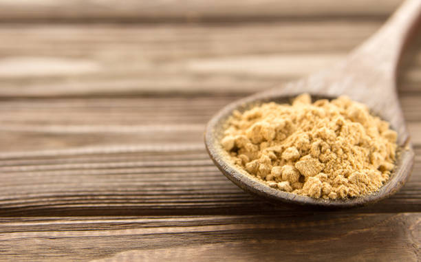 istock Ginger powder in wooden spoon on wooden table. 841167104