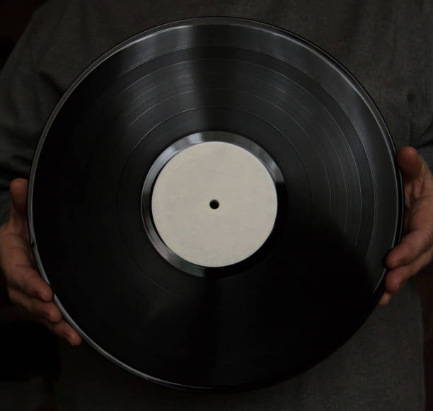 istock elderly woman holds a vinyl disk in her hands. 841167496