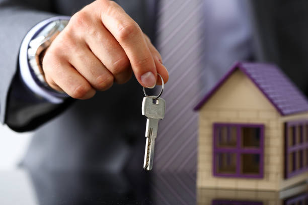 istock Man in suit and tie hold in hand silver key 841167588